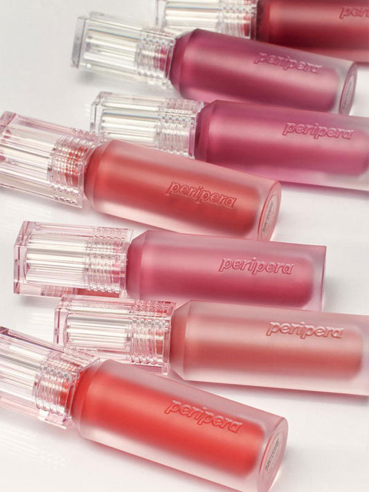 Peripera lip glosses in various shades on a light background